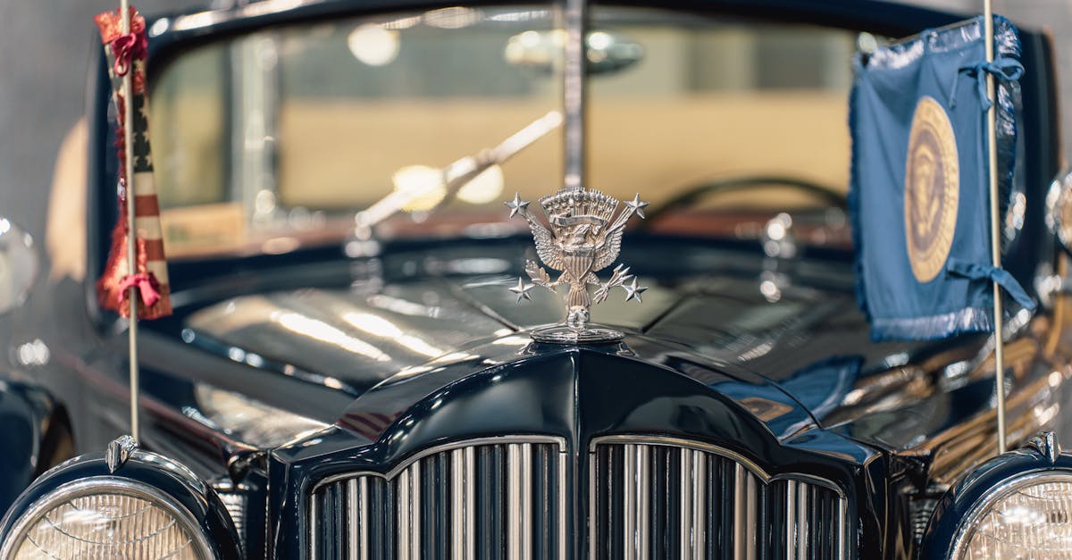 Close-up of a vintage ceremonial car with presidential emblem and flags displayed prominently.