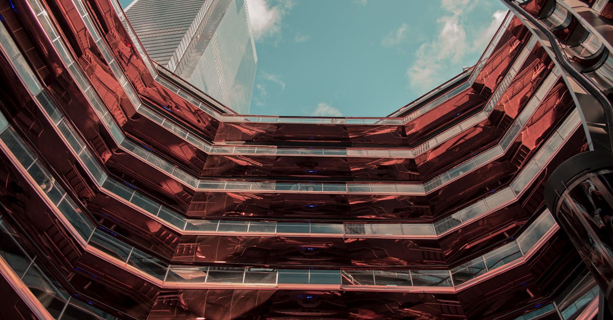 Futuristic architectural design featuring a copper facade and modern building elements under a clear blue sky.