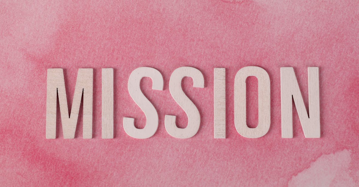 Wooden letters spelling 'MISSION' on a soft pink watercolor background.