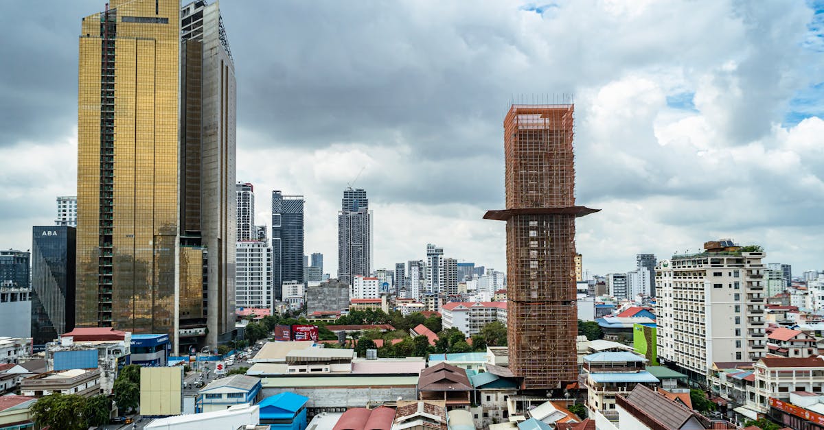 Aerial view of Phnom Penh featuring modern skyscrapers and urban architecture under a cloudy sky.