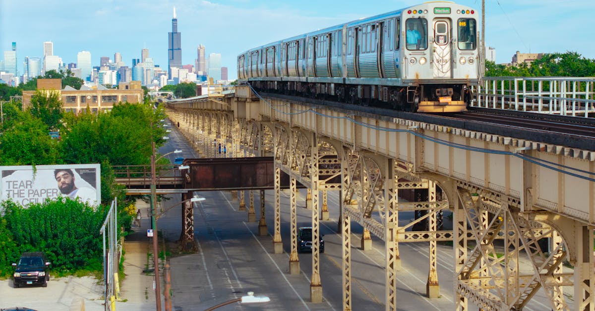 Elevated L train in Chicago with city skyline, featuring the Willis Tower.