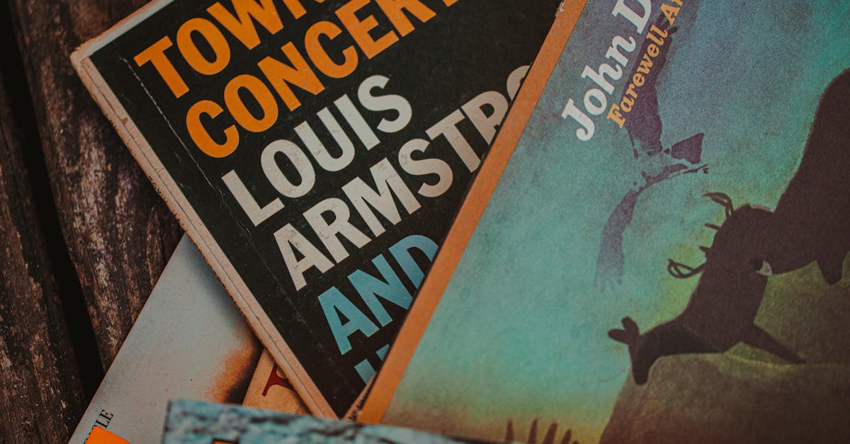 Close-up of vintage record covers showcasing John Denver and Louis Armstrong, Alabama setting.