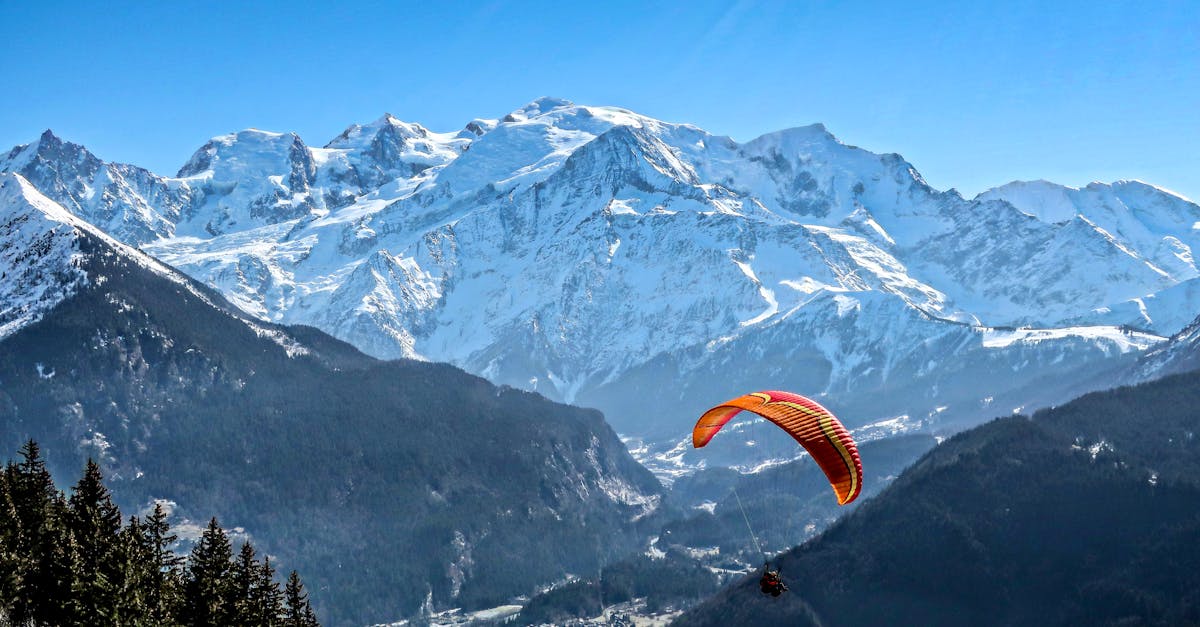 A thrilling paraglider soars over Mont Blanc in Passy, capturing the stunning winter mountain scenery.