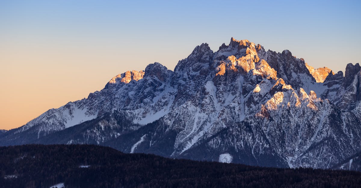 Breathtaking view of the snow-covered Dolomite mountains at sunset, highlighting nature's grandeur.