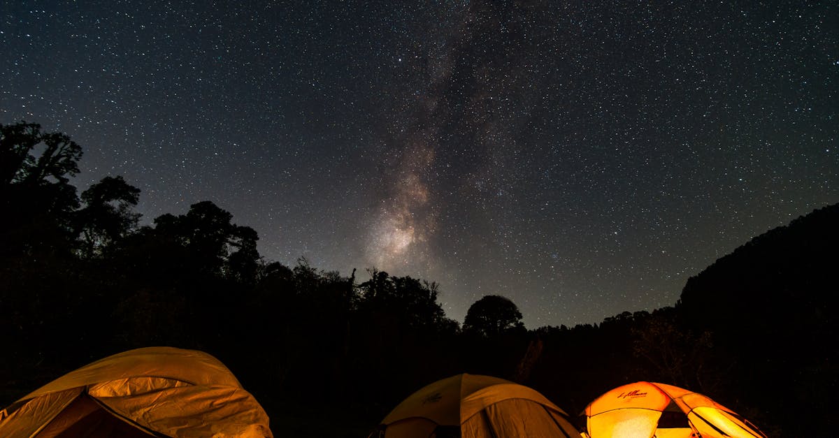 Captivating night camping scene in India with starry sky and glowing tents under the Milky Way.