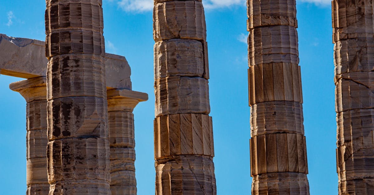 Close-up of ancient temple columns at Temple of Poseidon, Greece, under a vibrant blue sky.