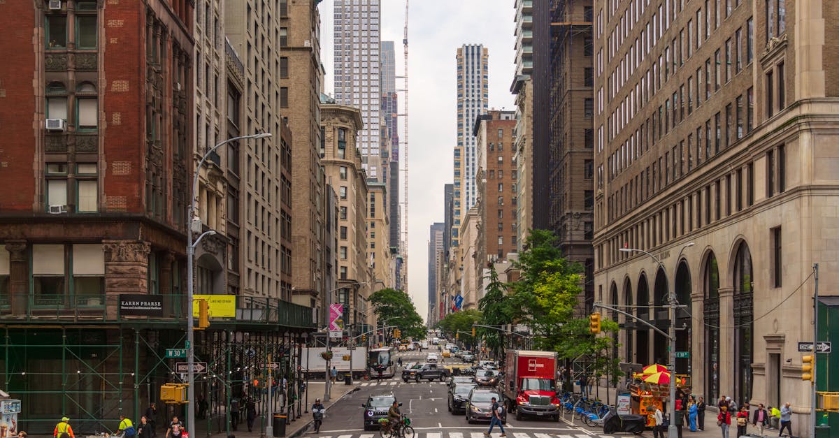 A busy street view of Midtown Manhattan with historic and modern buildings, pedestrians, and traffic.