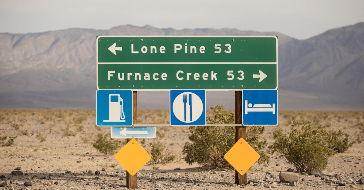 Signpost in desert landscape showing directions to Lone Pine and Furnace Creek in Death Valley.
