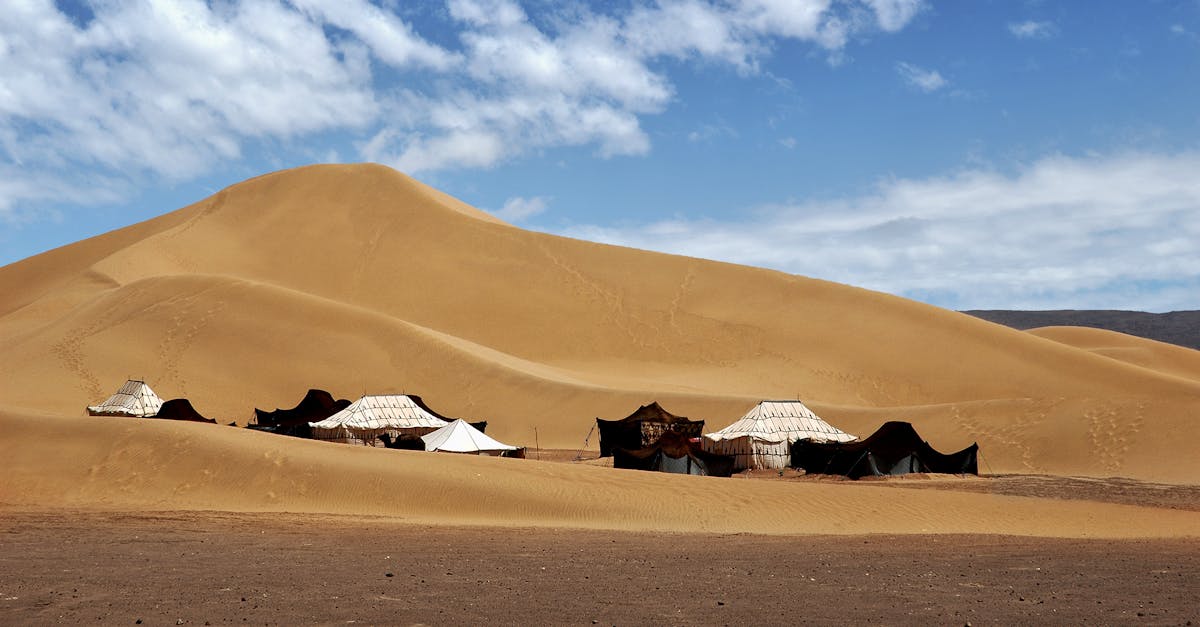 Nomadic tents amidst the stunning dunes of M'Hamid El Ghizlane in Maroc, perfectly capturing Saharan beauty.