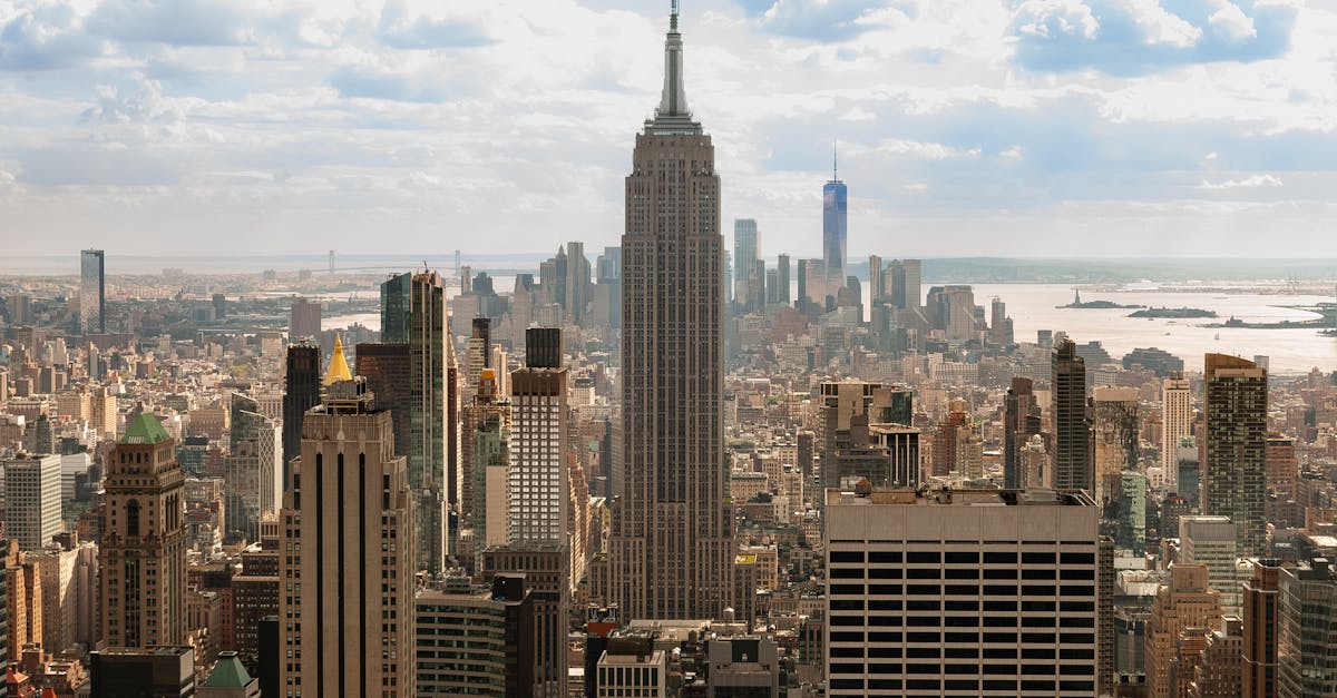 A breathtaking aerial view of New York City skyline featuring the iconic Empire State Building under a clouded sky.