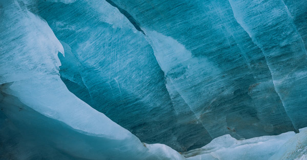 Detailed texture of blue glacier ice with smooth, layered patterns.