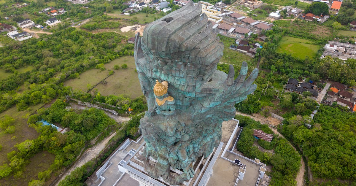 A breathtaking aerial shot of the Garuda Wisnu Kencana statue surrounded by lush greenery in Bali, Indonesia.