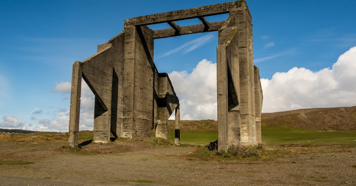 A striking concrete structure stands against a clear blue sky in a rural, open landscape.
