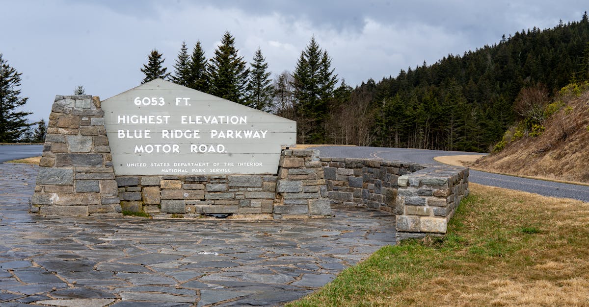 Blue Ridge Parkway sign at 6053 ft, highest elevation; scenic mountain road in North Carolina.