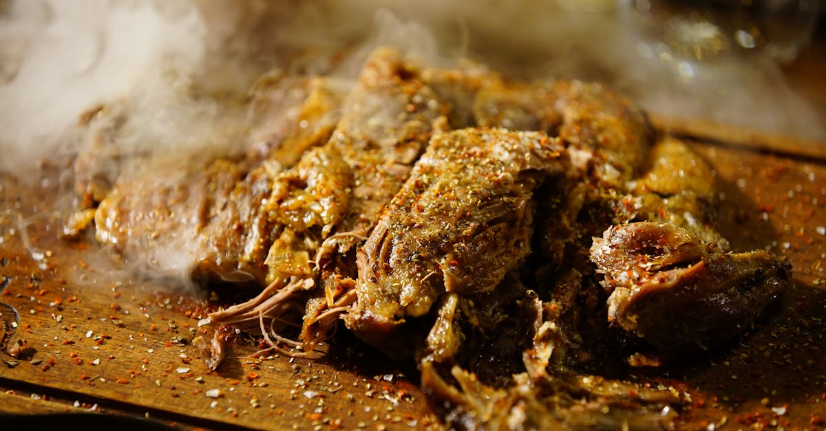 Delicious steaming pulled pork seasoned with spices, served on a wooden board, perfect for barbecue enthusiasts.
