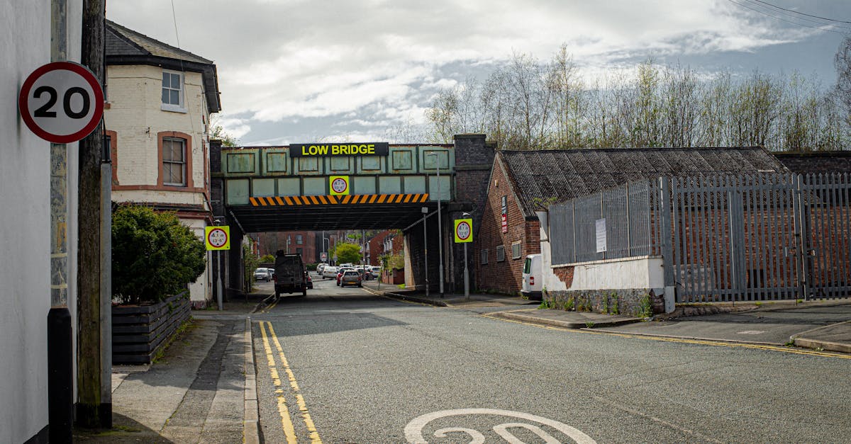 Street view in Liverpool featuring a low bridge and various traffic signs including speed limit indicators.