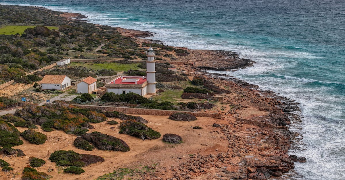 Breathtaking aerial view of a lighthouse on Mallorca's rugged coast in the Balearic Islands, Spain.