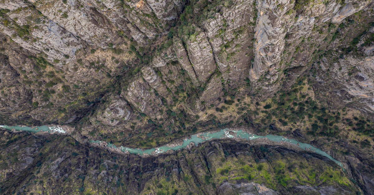 Stunning aerial shot of a canyon with a winding river in Antalya, Türkiye, showcasing rocky cliffs and vibrant nature.