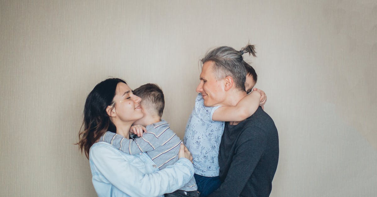 A heartfelt family moment with parents embracing their children indoors.