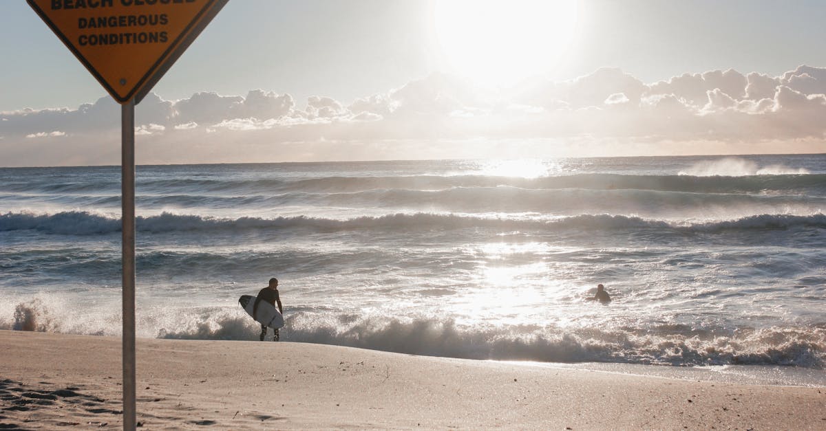 Surfer defies beach closure at Bronte, Australia, with dangerous waves crashing in the sunlight.