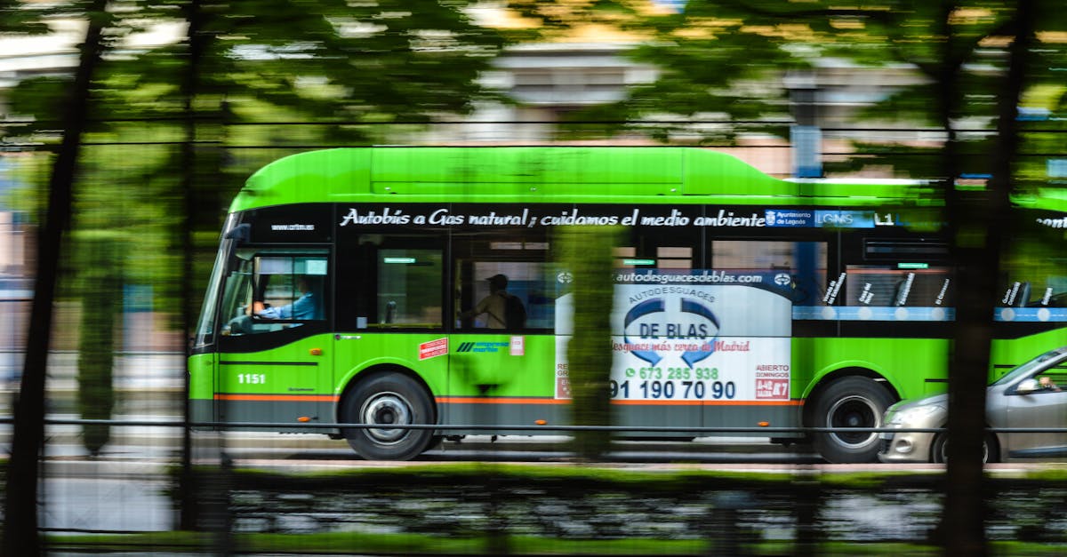 A green natural gas bus in motion on a city street, emphasizing eco-friendly transportation.