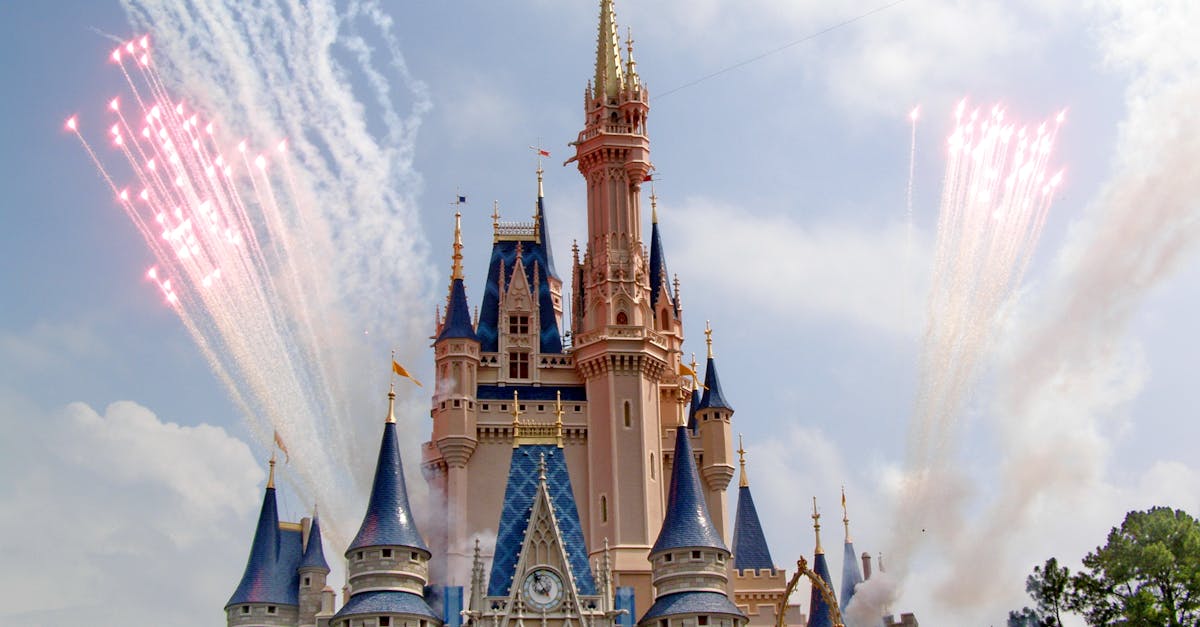 Amazing princess castle with colorful ornamental details located in amusement park during fireworks