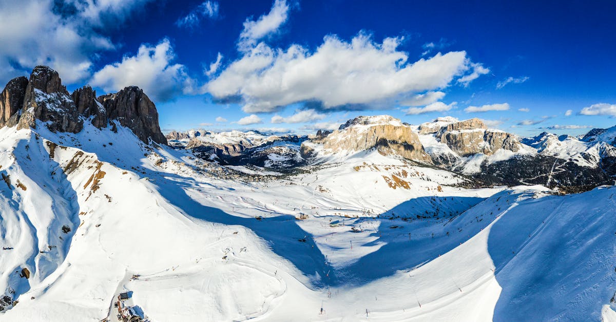 Breathtaking aerial view of snow-covered mountain ranges under a clear blue sky in winter.