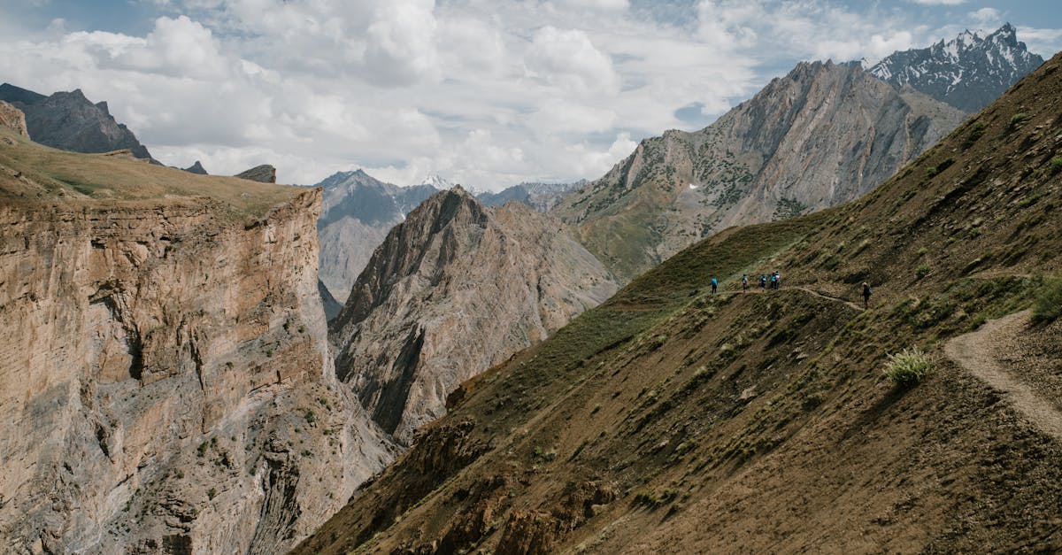 Breathtaking scenery of huge rocky mountain range with sharp peaks against cloudy blue sky