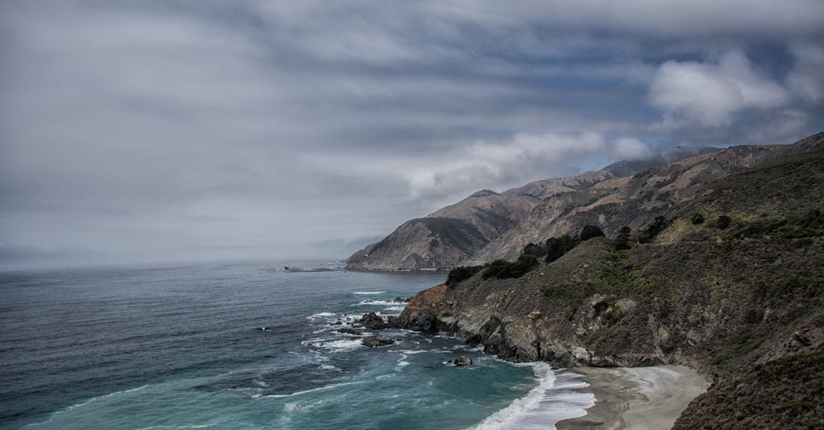 Dramatic coastal landscape of Big Sur, California, showcasing rugged cliffs and ocean waves.