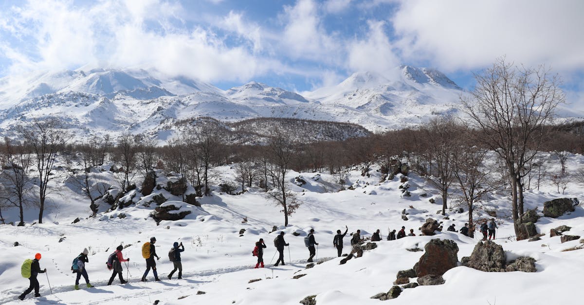 A group of hikers enjoying a snowy landscape in Aksaray, Türkiye with scenic mountain views.