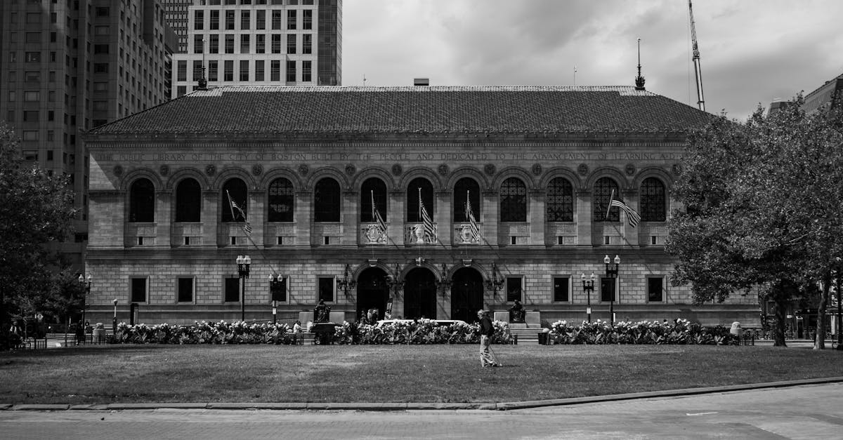 Stunning black and white view of the Boston Public Library's symmetrical facade with urban backdrop.
