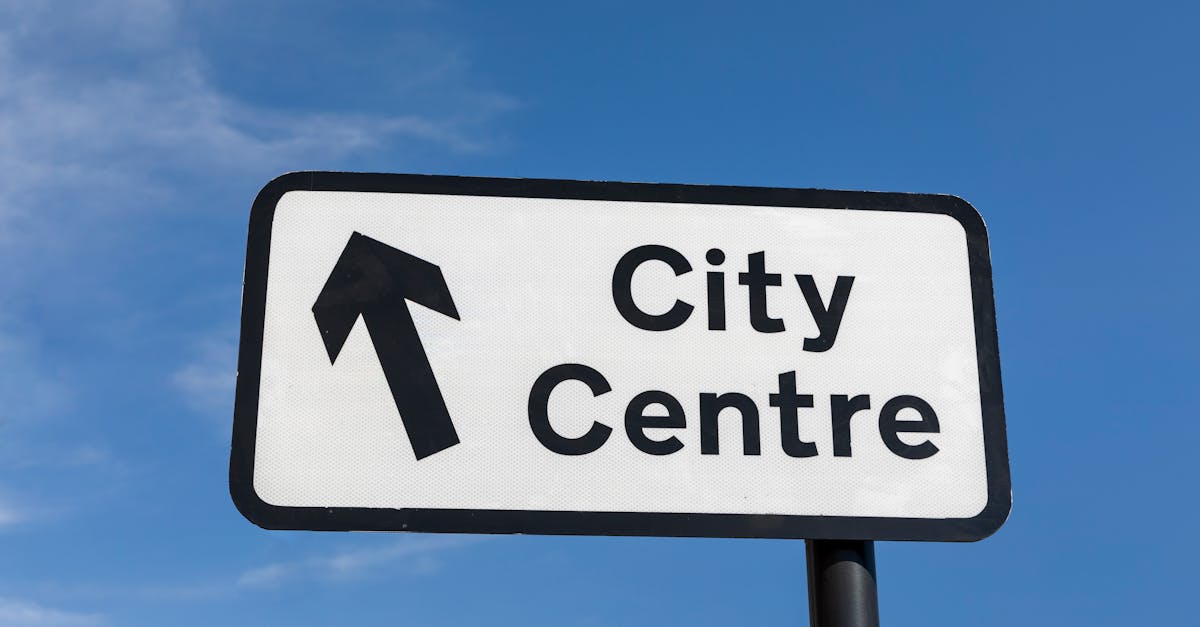 A directional sign pointing towards the city centre under a clear blue sky.
