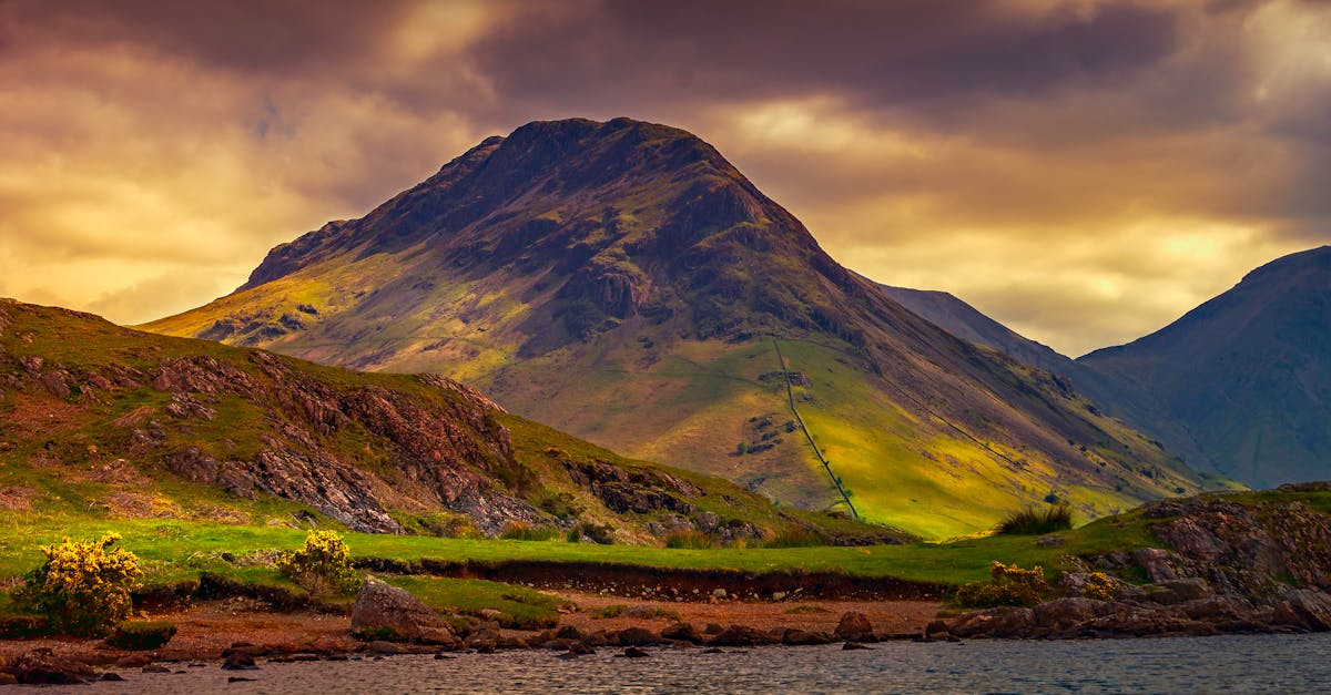 Stunning mountainous landscape with dramatic clouds and warm sunset lighting.