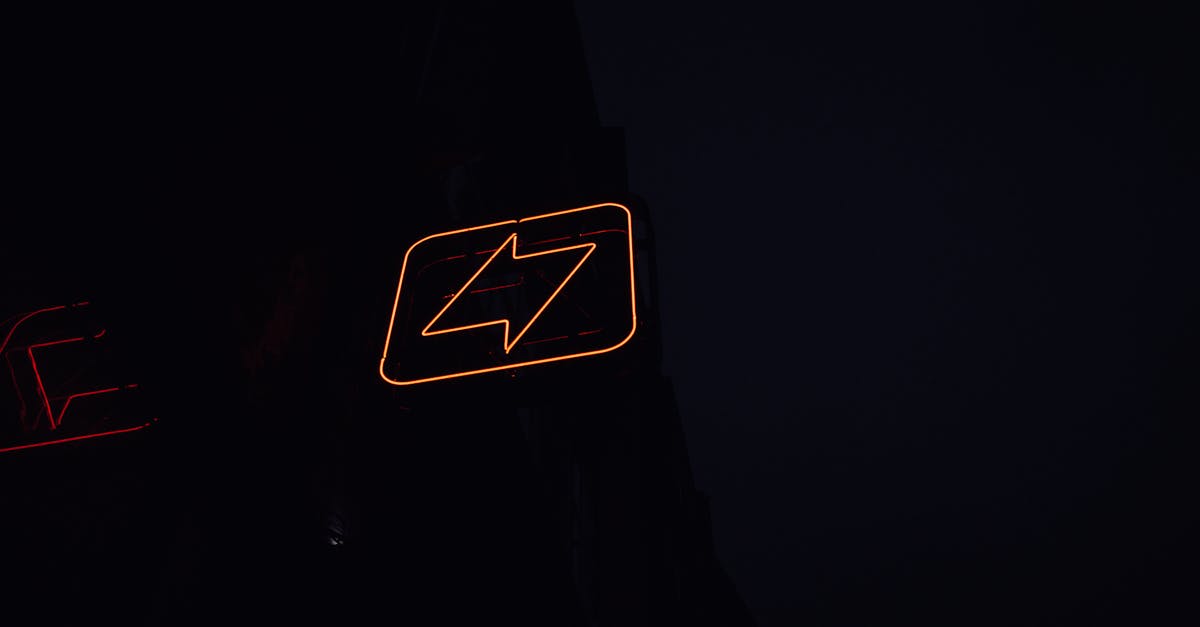 A glowing neon lightning bolt sign against a dark night background, symbolizing energy and electricity.