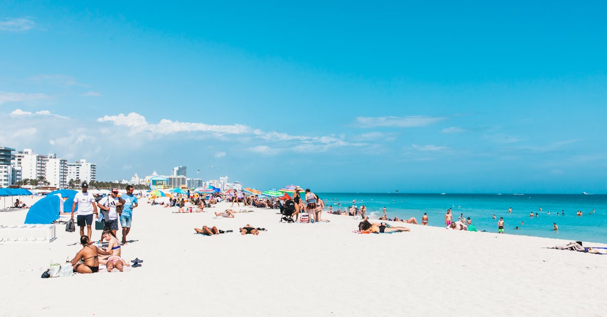 A lively summer day at Miami Beach with sunbathers and colorful umbrellas.