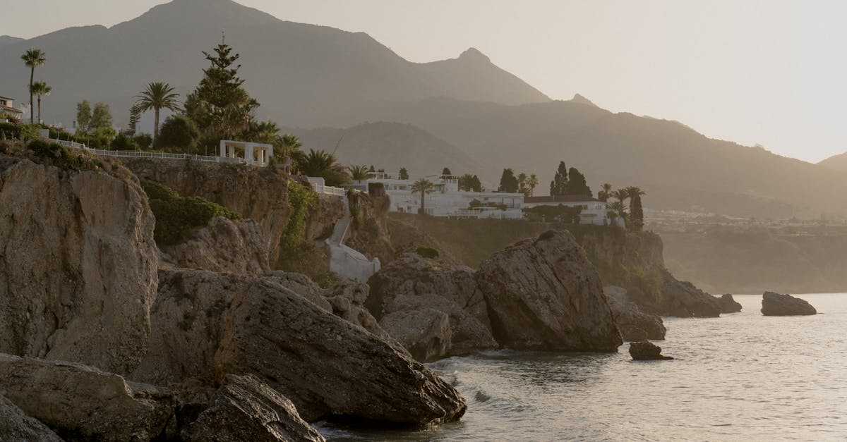 Breathtaking view of coastal cliffs and mountains bathed in sunrise light along the Mediterranean coast.