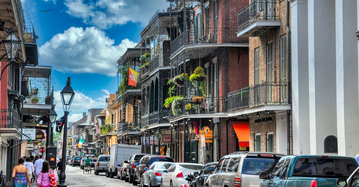 Vibrant day in New Orleans' French Quarter with people walking and historic architecture lining the street.