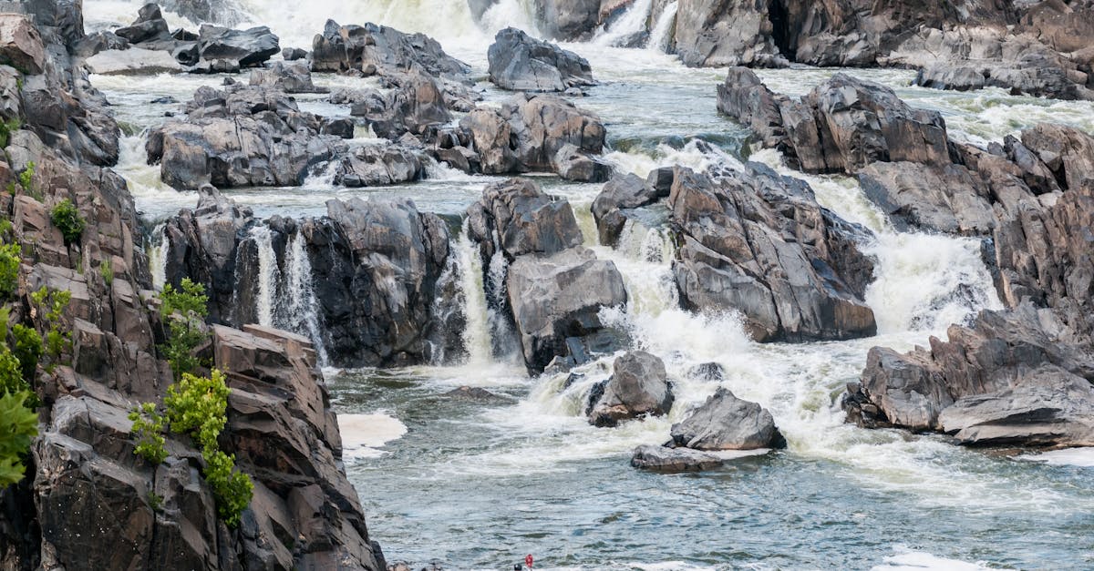 Experience an exhilarating kayaking adventure navigating through rocky rapids with breathtaking waterfalls.