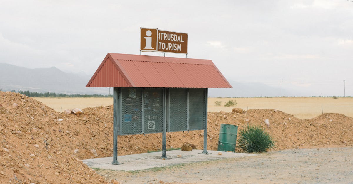 Abandoned tourism information stand in a desolate rural area with overcast skies.
