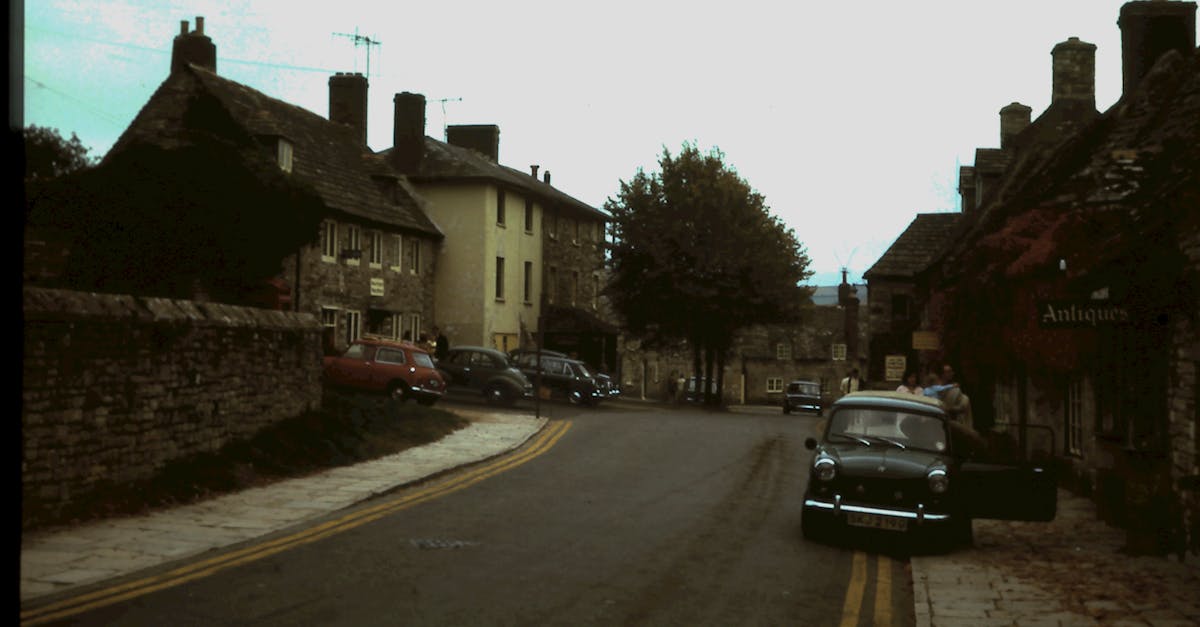 A quaint street in a historic town featuring vintage buildings and a classic car, evoking nostalgia.