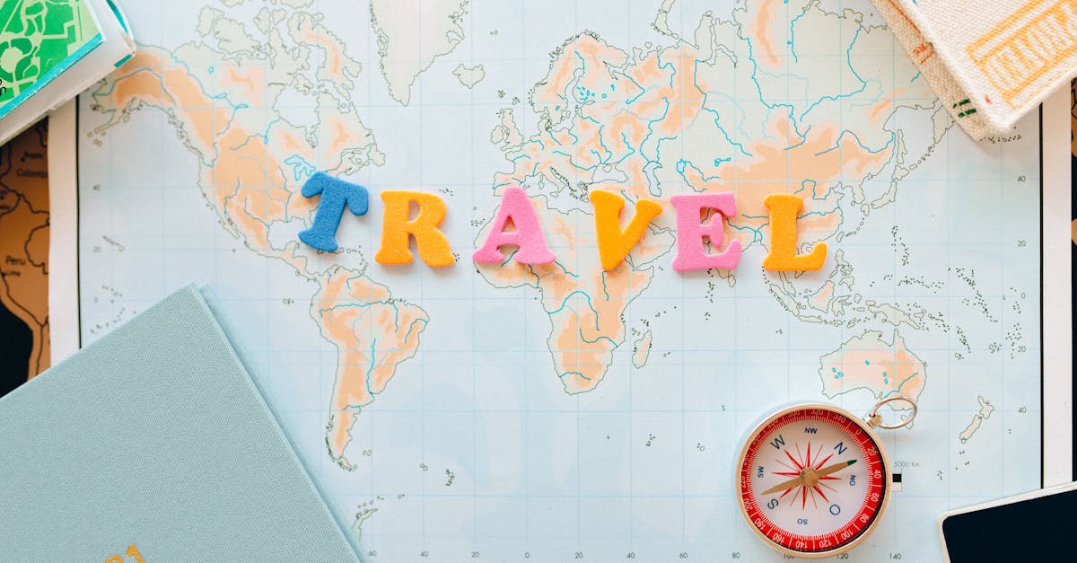 Flat lay of a map with colorful letters "TRAVEL" and a compass for planning adventures.