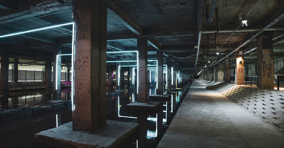 Explore the eerie ambiance of an abandoned industrial structure illuminated by neon lights and water reflections.