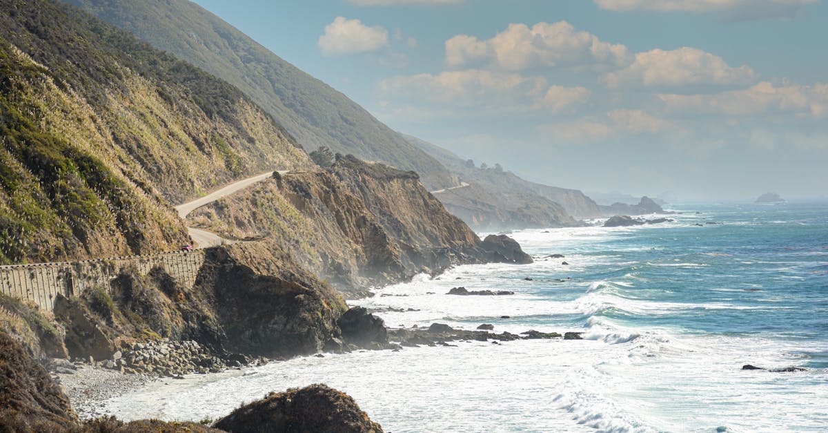 Captivating view of California's coastal highway along the rocky shore with ocean waves crashing.
