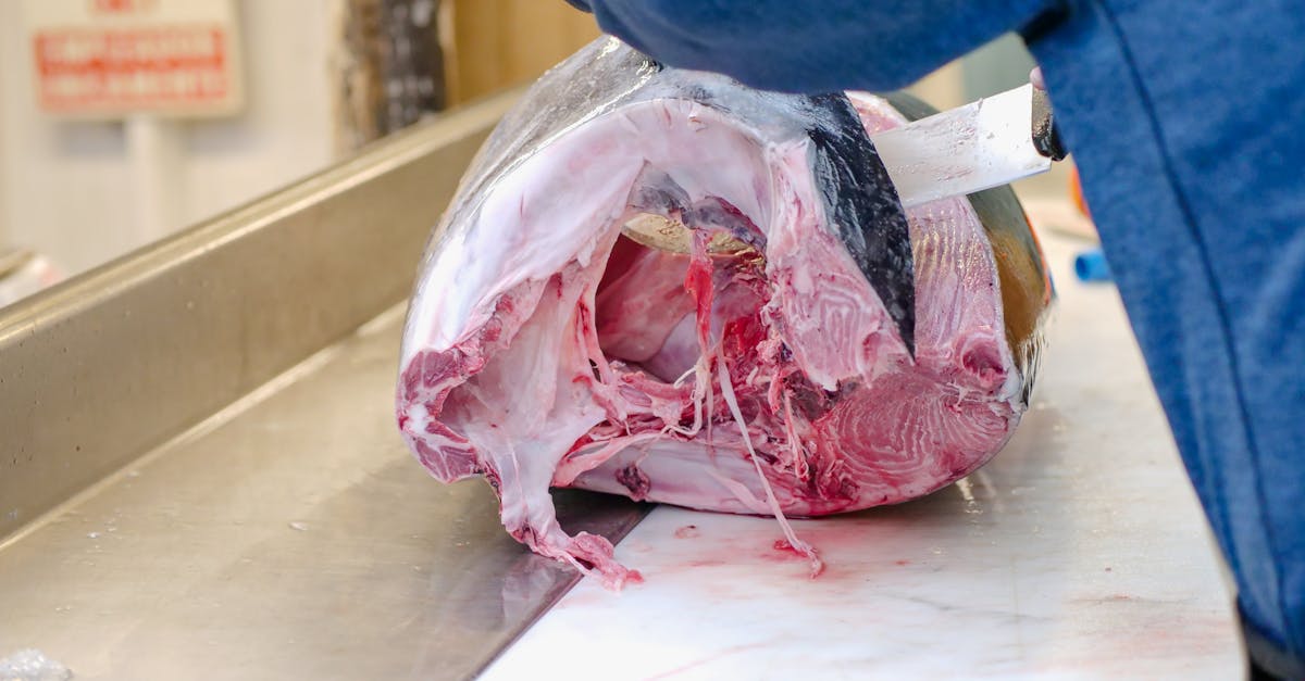 Image of raw Yellowfin tuna being expertly sliced, showing fresh seafood preparation.