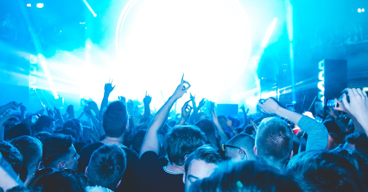 Energetic crowd enjoying a vibrant live concert with dazzling lights and lively atmosphere.