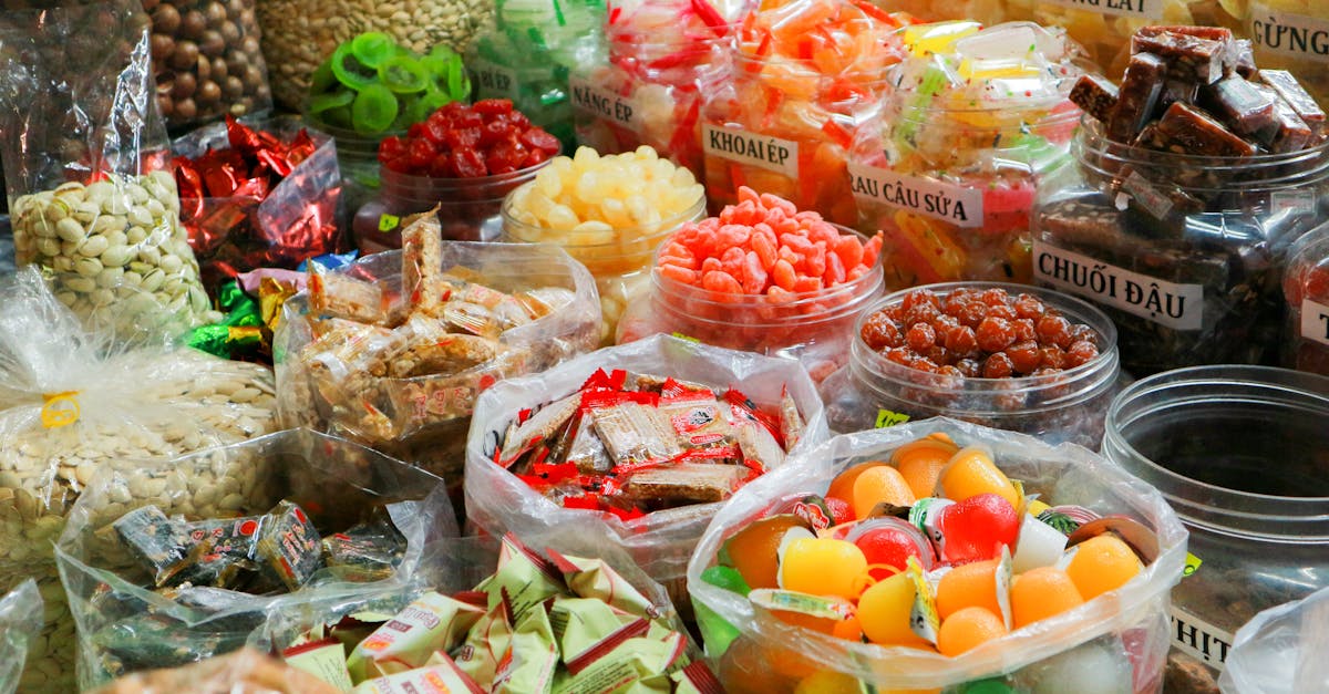 Colorful variety of traditional market sweets in plastic containers and bags.