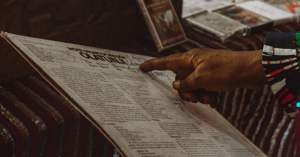 Detailed image of a hand pointing at a newspaper page, emphasizing engagement.