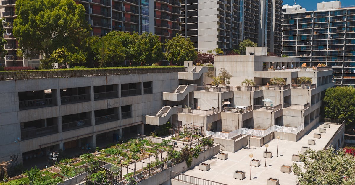 Aerial view of a rooftop garden on a concrete building in an urban area with high-rise apartments.