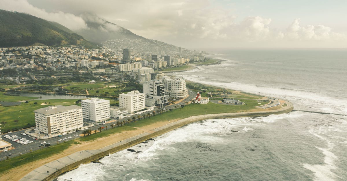 A breathtaking aerial view of Cape Town's coastline and urban landscape under a cloudy sky.