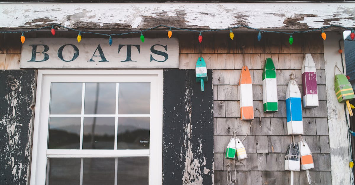 A charming rustic boathouse featuring colorful buoys and string lights, ideal for coastal themes.